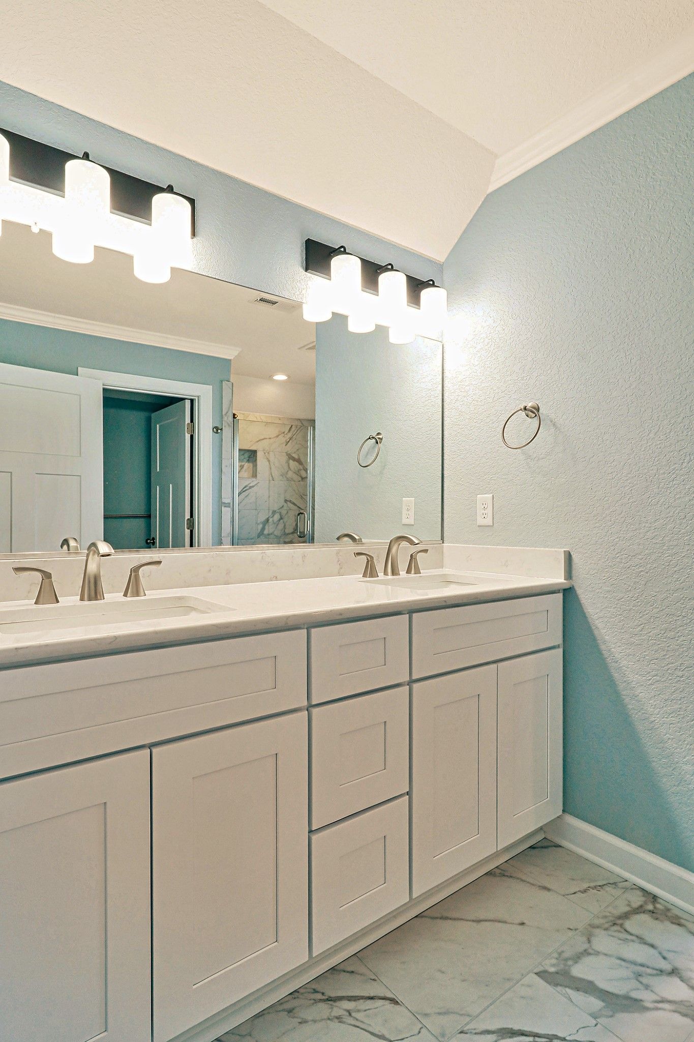 A bathroom with two sinks and a large mirror