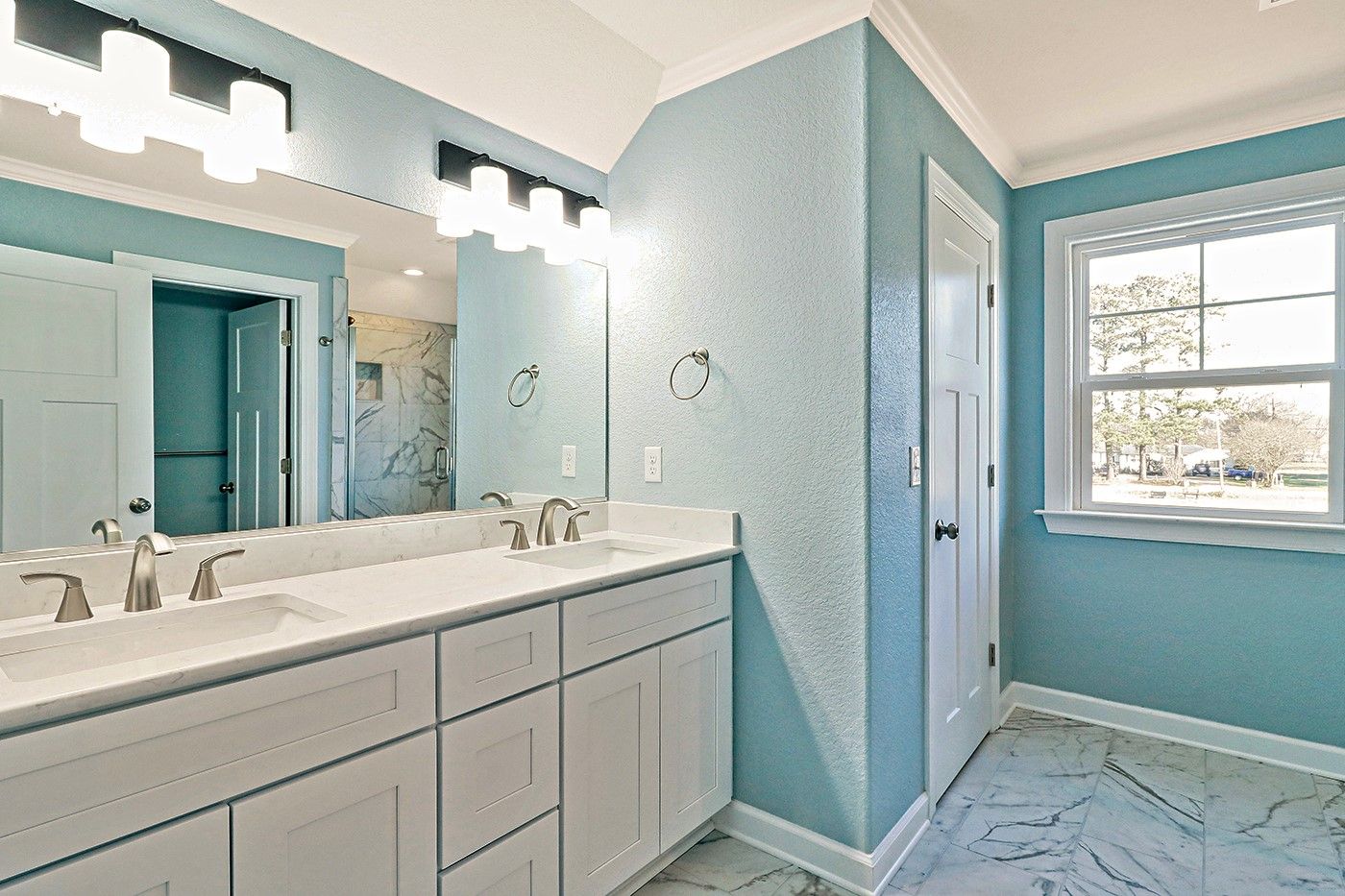 A bathroom with two sinks and a large mirror.