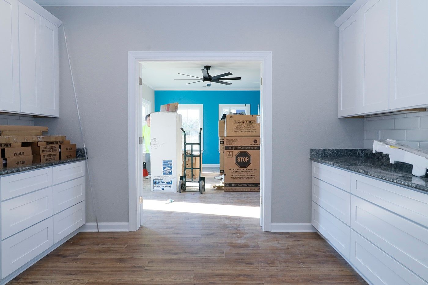 A kitchen with white cabinets and granite counter tops is being remodeled.