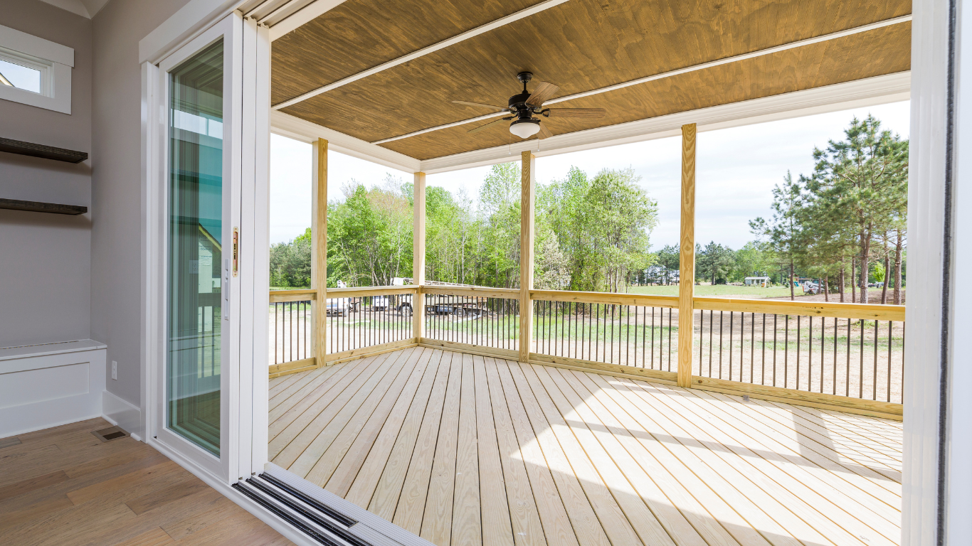 A screened in porch with sliding glass doors and a ceiling fan.