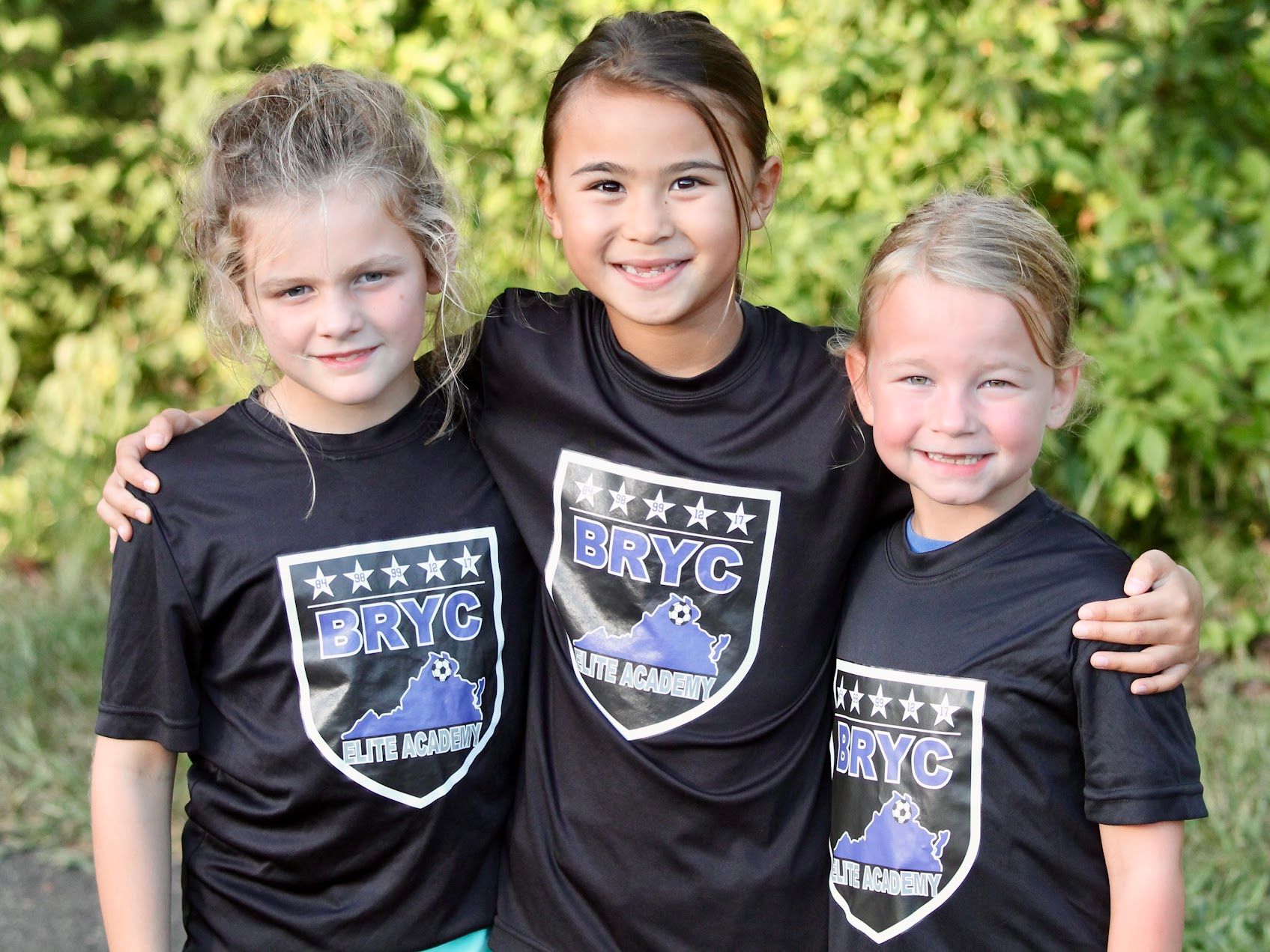 Three children smiling from a BRYC Academy team