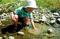 Young boy playing near the water