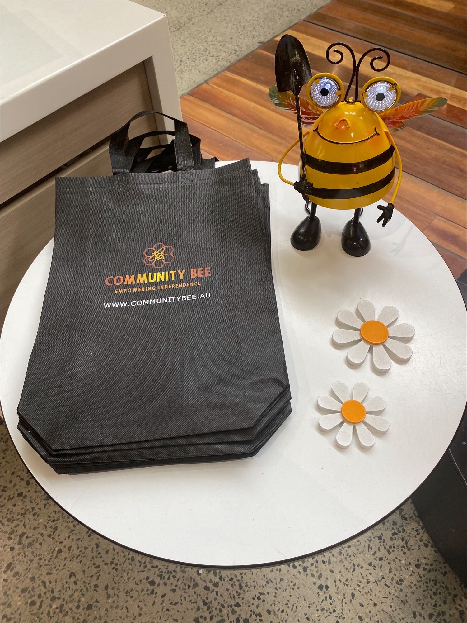 Pink and white ruffled flower, blue pansies, green leaves, dark soil.