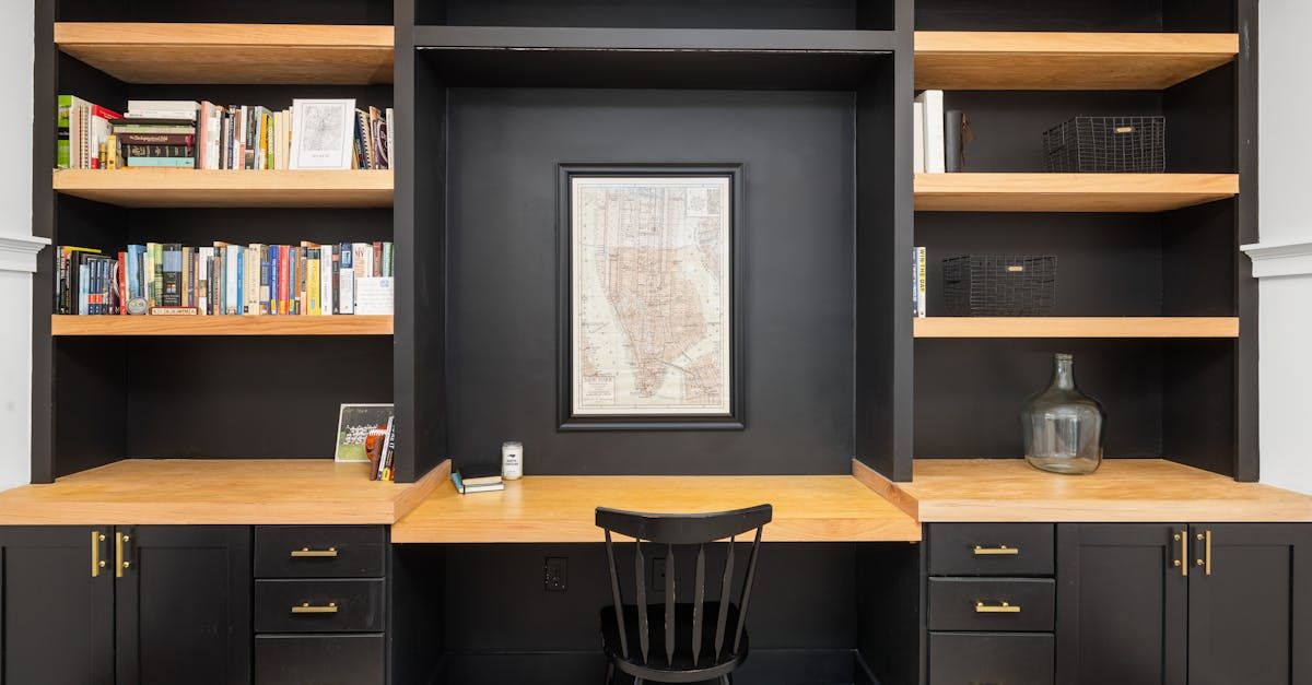 A home office with a desk, chair, shelves, and a map on the wall.