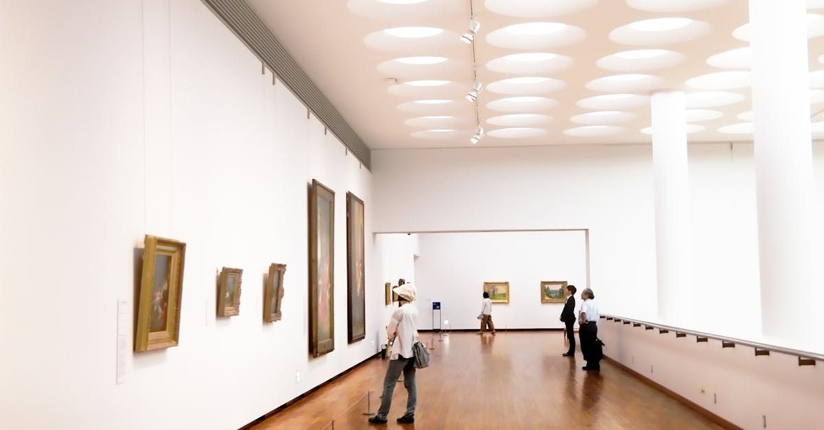 A group of people are looking at paintings in a museum.