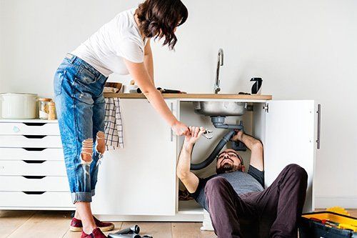 Man and Woman Fixing Sink — Fresno, CA — Art Douglas Plumbing Inc.
