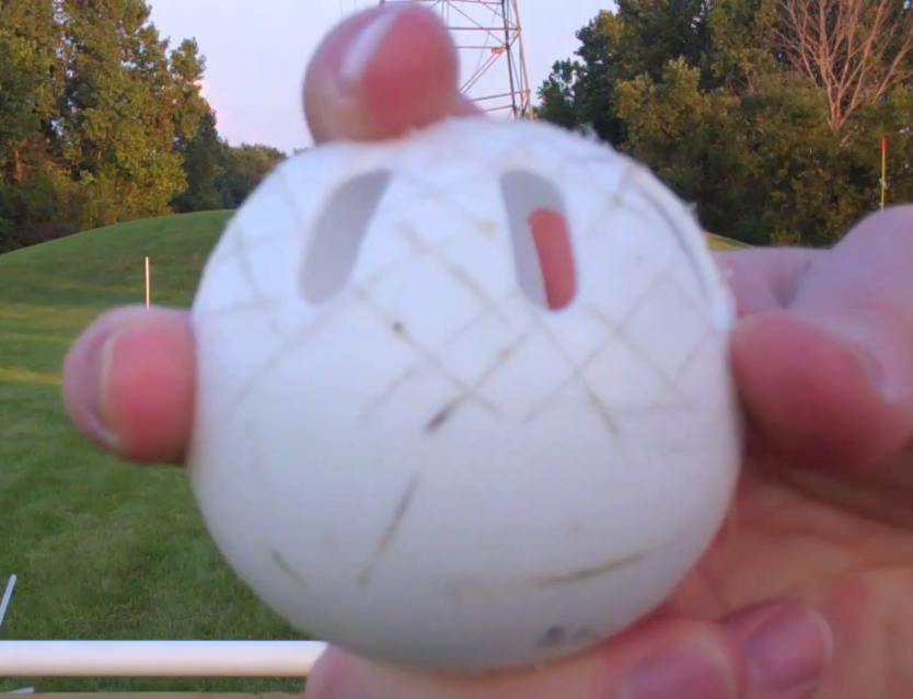 A person is holding a white ball with holes in it