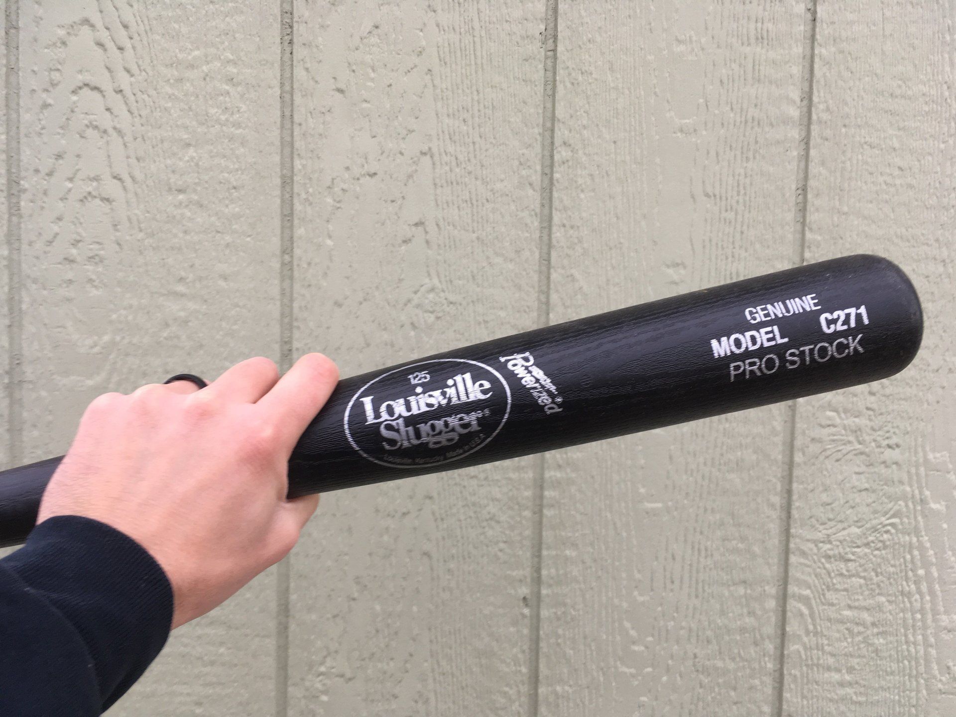A person is holding a louisville slugger baseball bat in their hand.