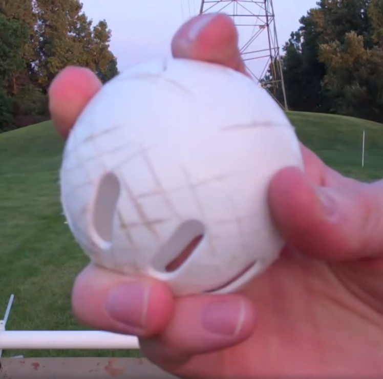A person is holding a white ball with a hole in it