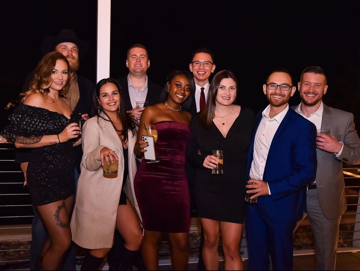 A group of people standing next to each other holding drinks.