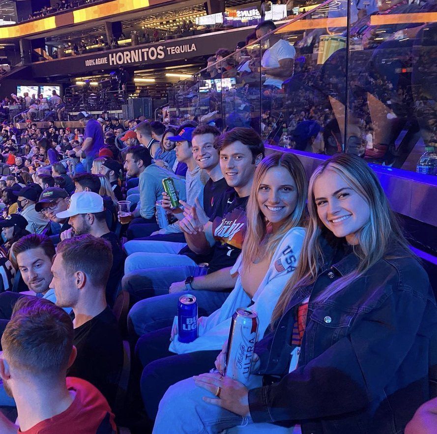 A group of people are sitting in a stadium with a sign that says hornitos