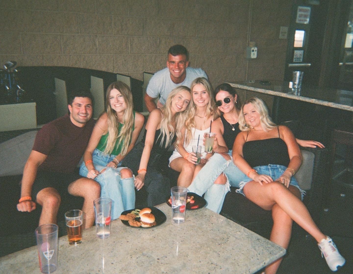 A group of people are posing for a picture while sitting around a table