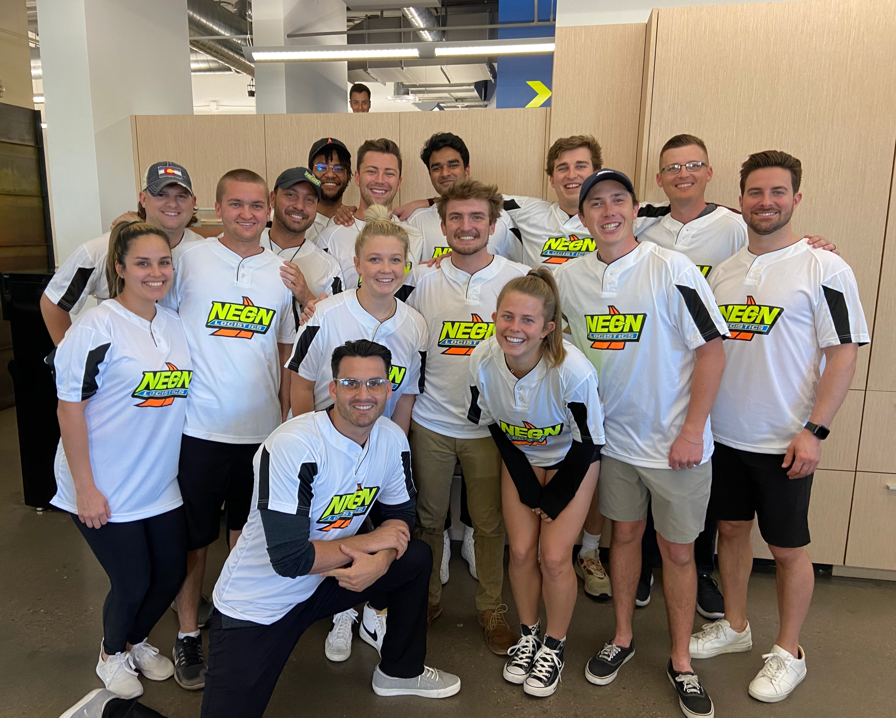 A group of people wearing white shirts with the word subway on them are posing for a picture.