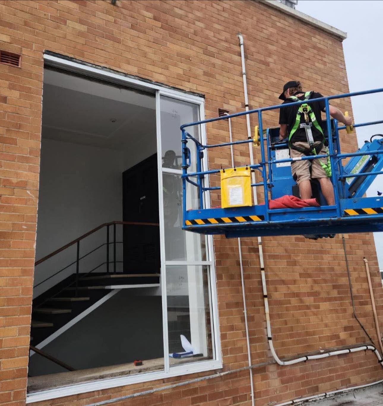 Galziers on a lift installing windows — Cessnock Glass in Cessnock, NSW