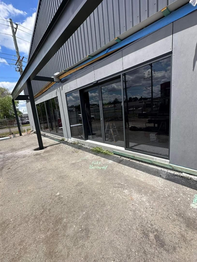 A Large Building With a Lot of Windows is Being Built — Cessnock Glass in Cessnock, NSW