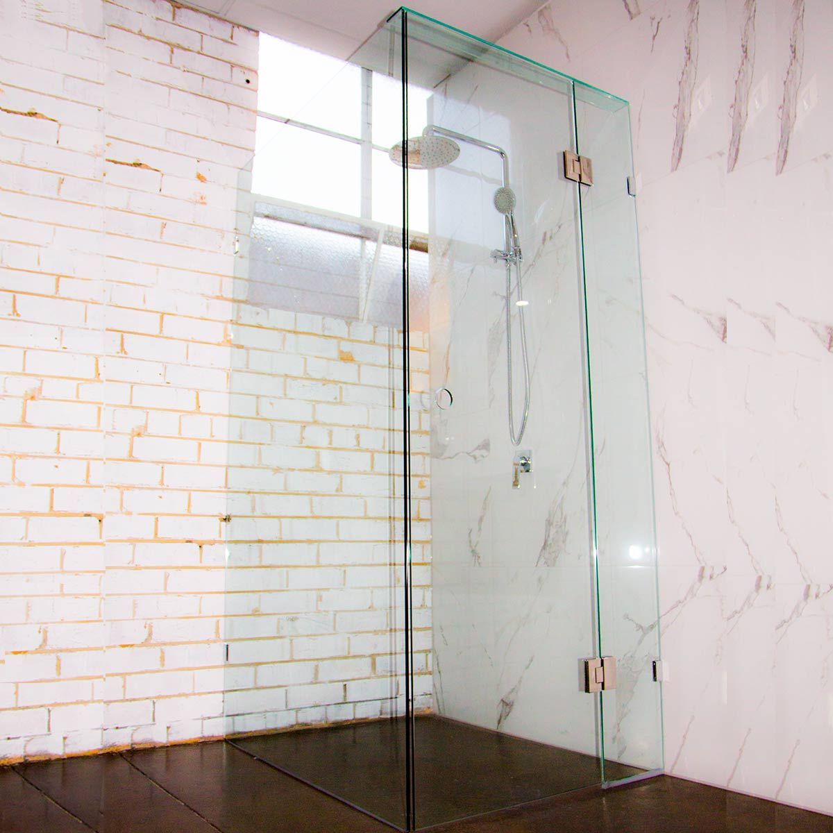 Glass shower enclosure with brick wall and marble wall behind it  — Cessnock Glass in Cessnock, NSW