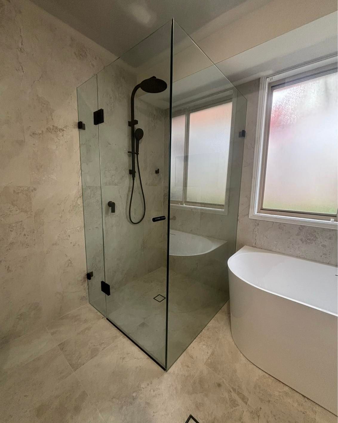 A shower screen in a central coast house with a bath to the right — Cessnock Glass in Central Coast, NSW