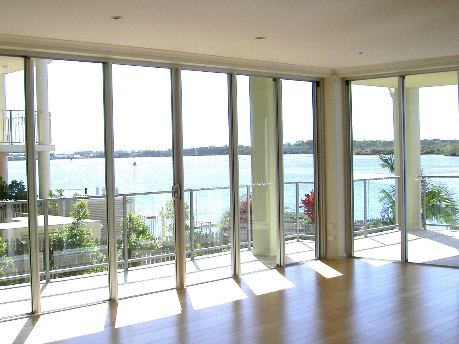 Bright room with large windows overlooking a body of water and surrounding structures — Cessnock Glass in Cessnock, NSW