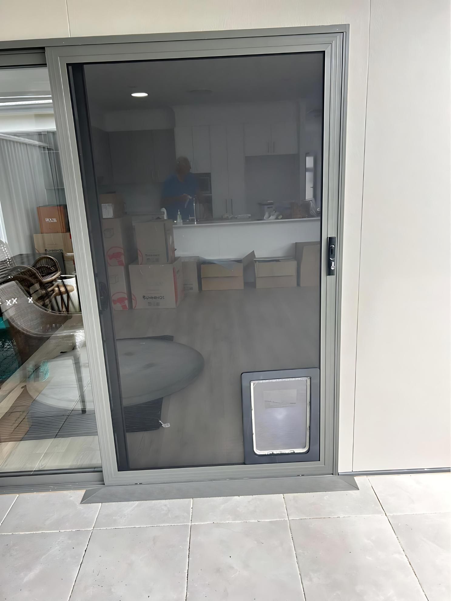 A Sliding Glass Door With a Cat Door Attached to It — Cessnock Glass in Cessnock, NSW