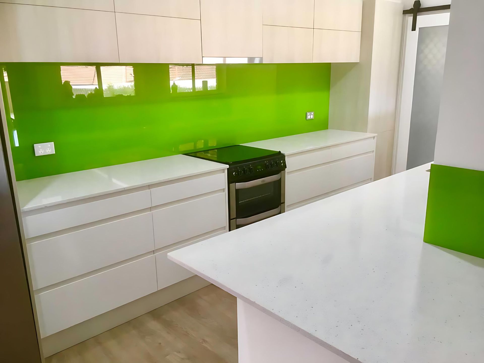A Kitchen With a Green Backsplash and White Cabinets — Cessnock Glass in Cessnock, NSW