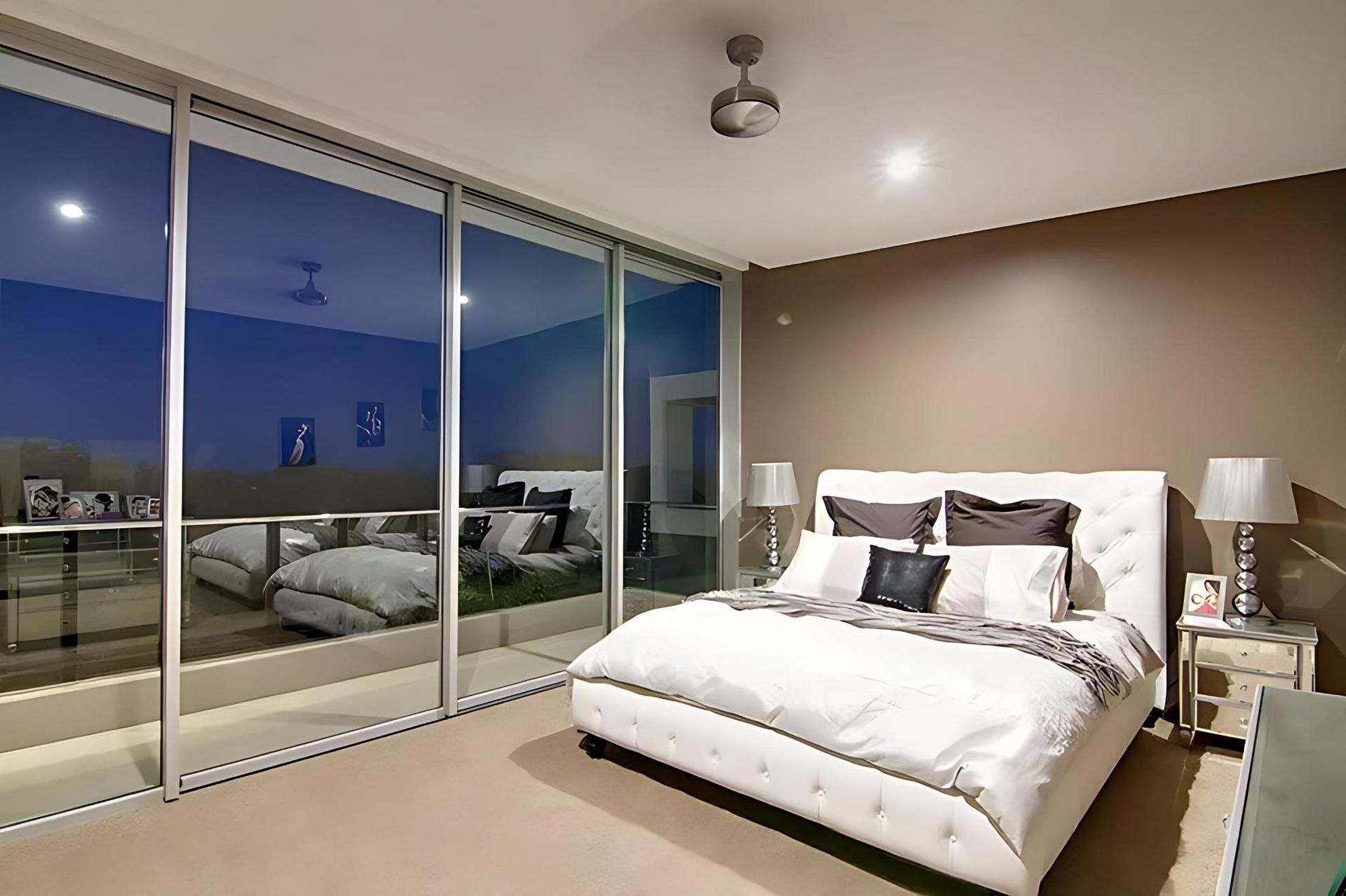 A Bedroom With a Large Bed and Sliding Glass Doors — Cessnock Glass in Cessnock, NSW