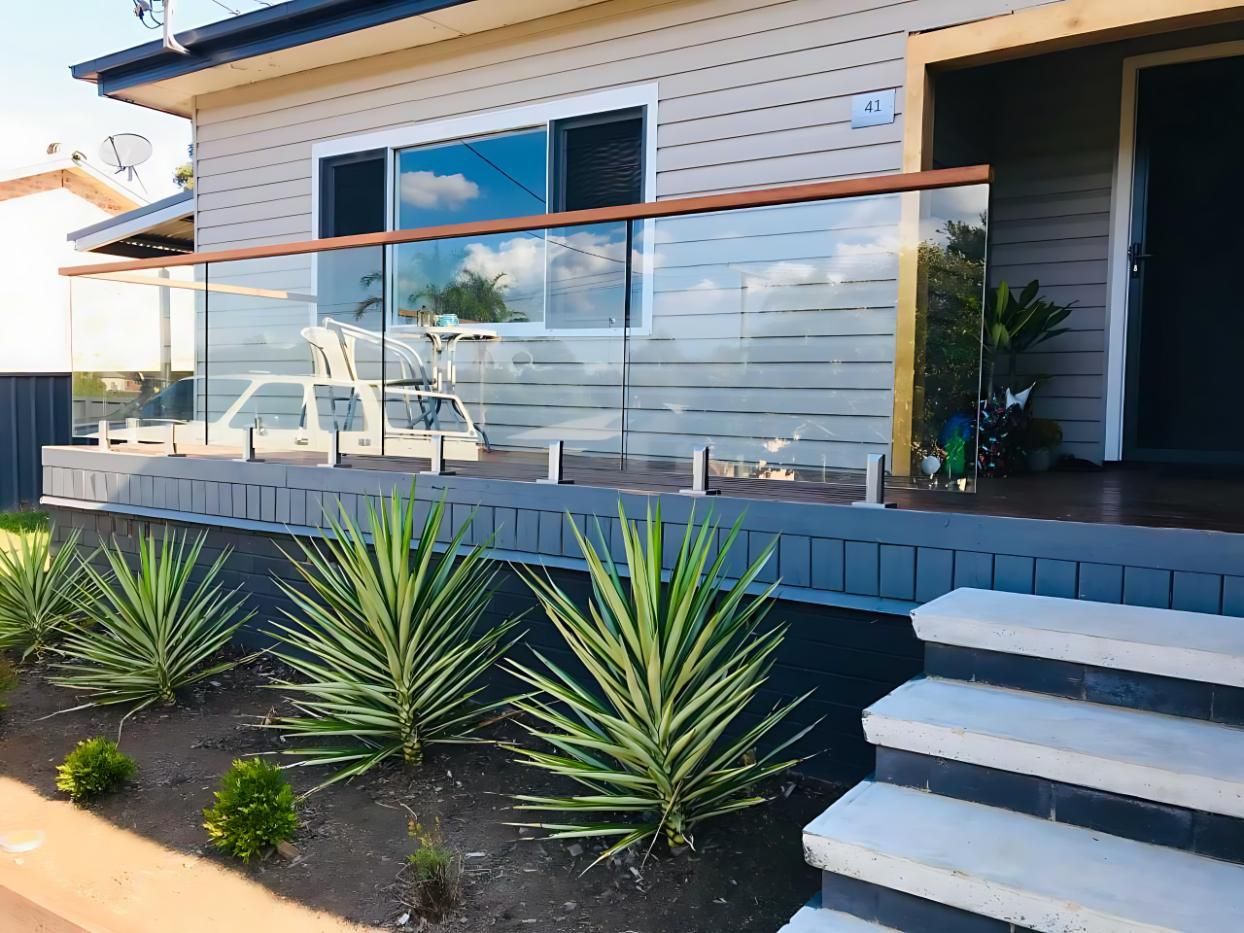 A House With a Glass Railing and Stairs in Front of It — Cessnock Glass in Maitland, NSW
