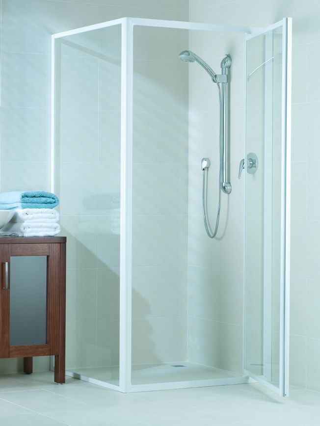 White framed shower enclosure with glass doors, showerhead, and wooden cabinet with towels — Cessnock Glass in Central Coast, NSW