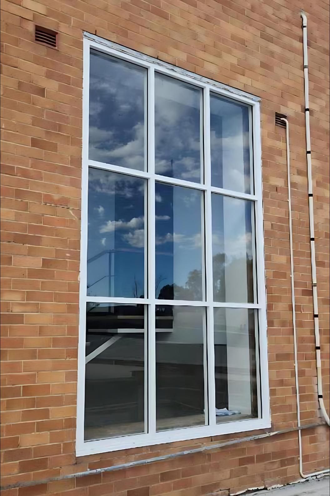 A Large Window on the Side of a Brick Building — Cessnock Glass in Central Coast, NSW