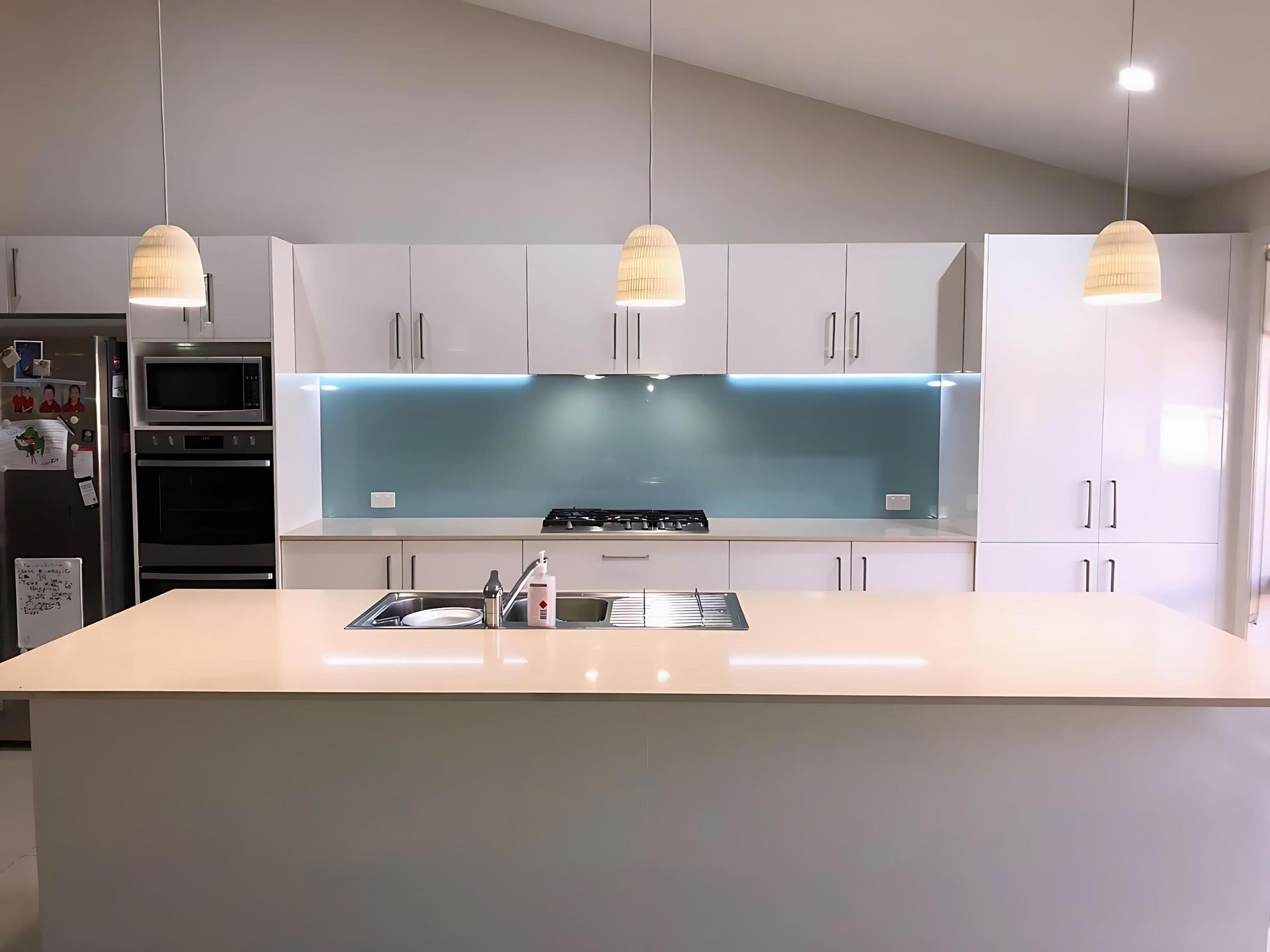 A Kitchen With White Cabinets and a Large Island — Cessnock Glass in Maitland, NSW