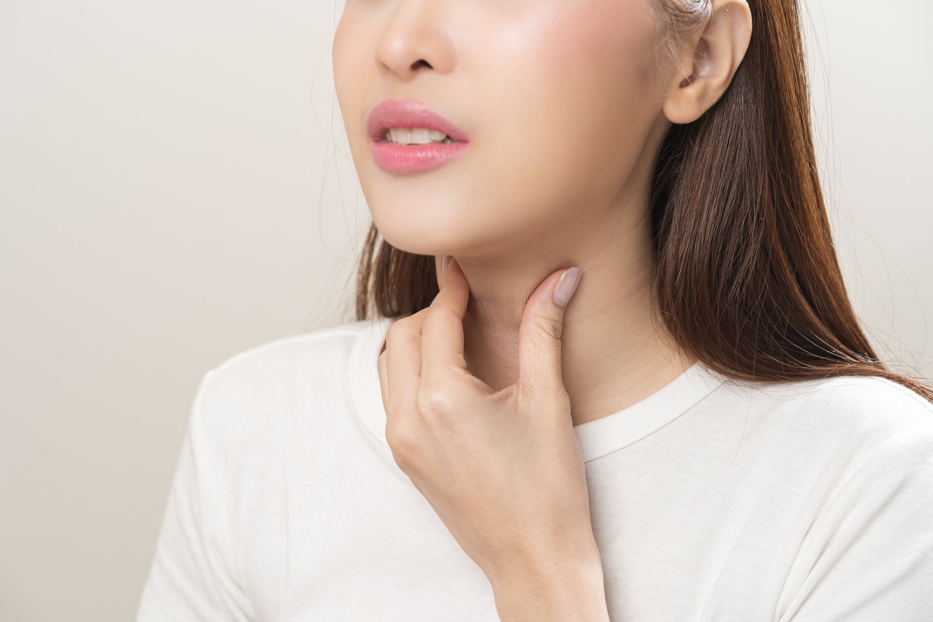 Woman touching her neck, possibly indicating pain or discomfort.