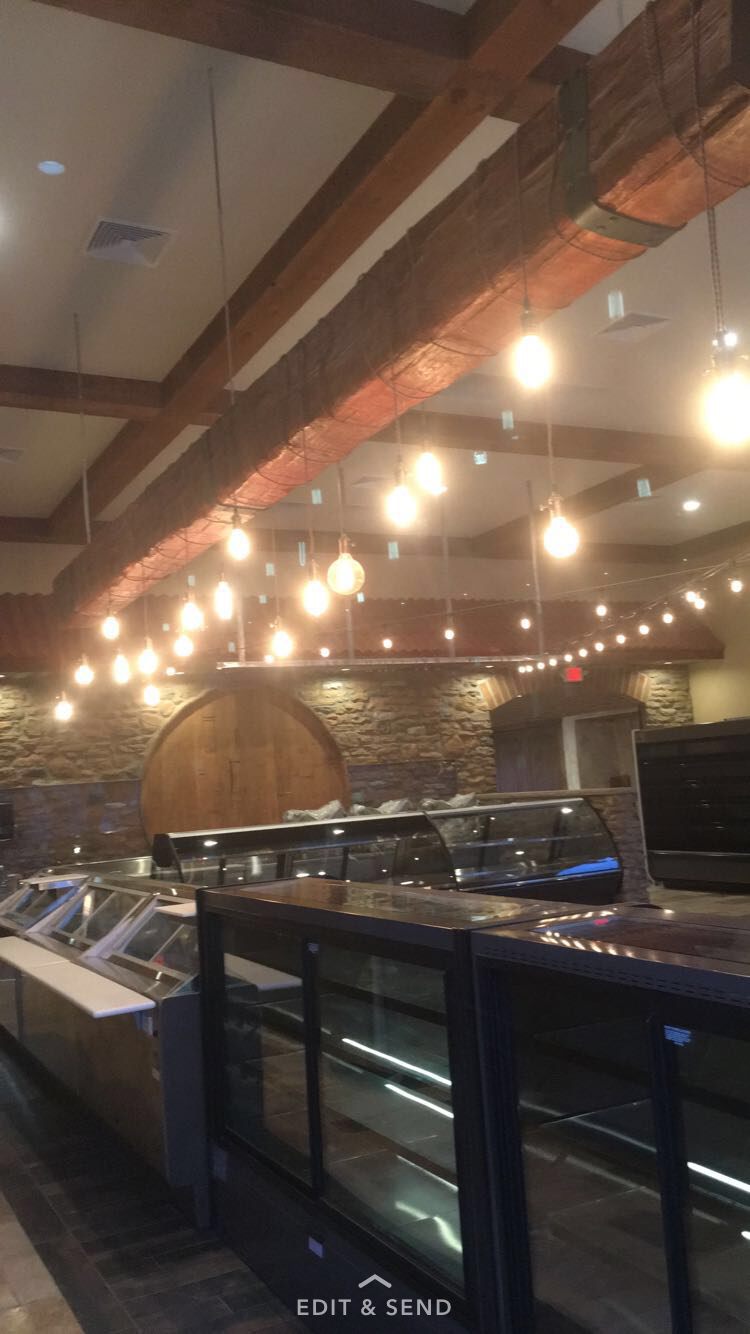 A restaurant with a lot of lights hanging from the ceiling.