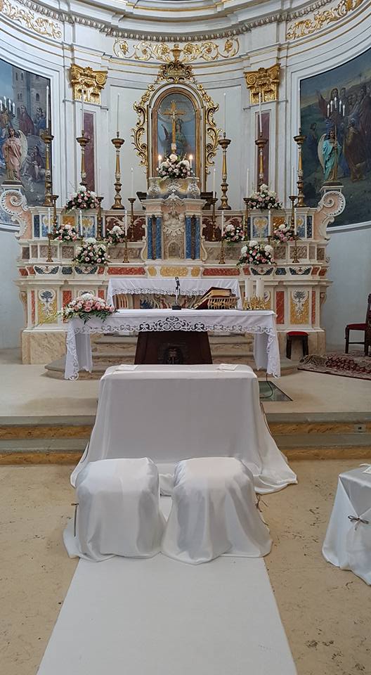 altare di una chiesa con addobbi floreali