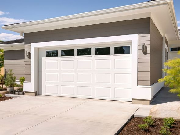 A modern house with a large garage door and a driveway.