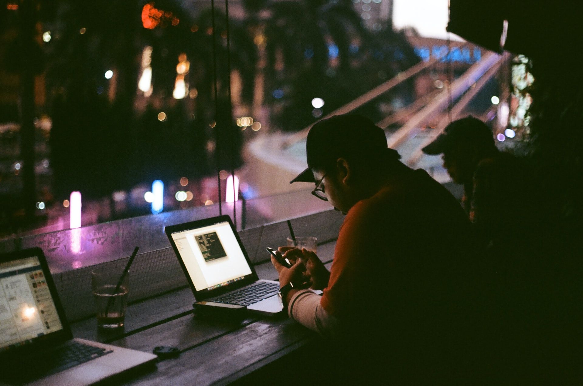 Image showing a person on a laptop and mobile phone in the dark
