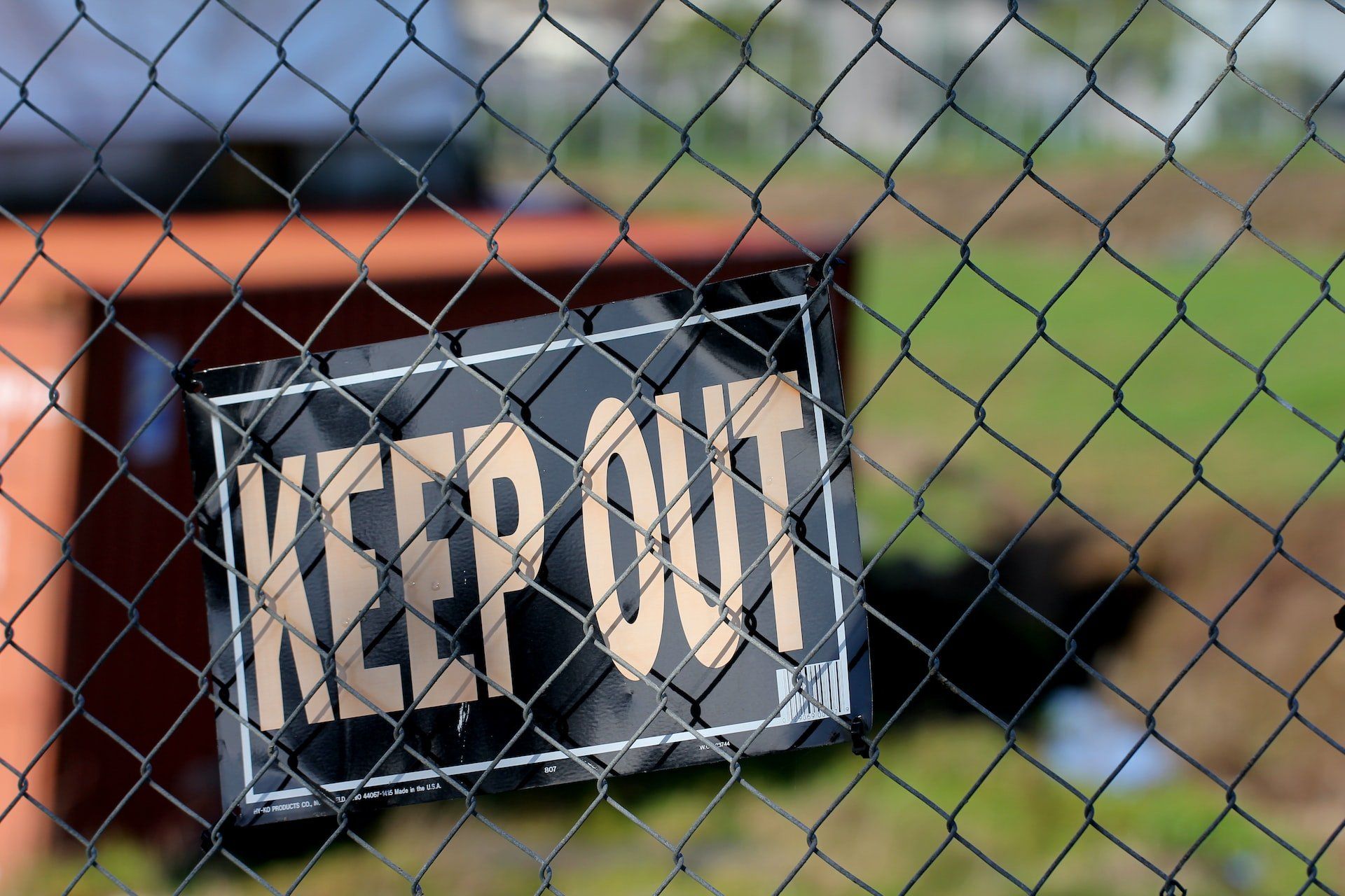 a sign saying keep out on a fence