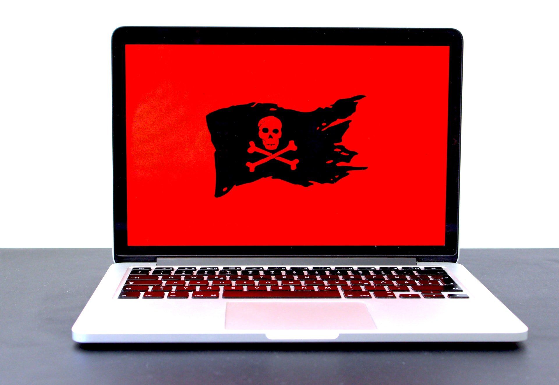Image of a laptop with a skull and crossbones flag signifying danger