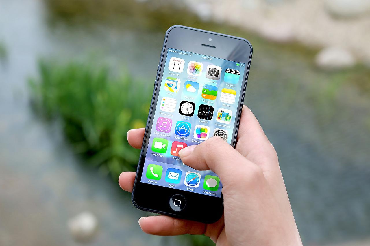 Image of a mobile phone in someone's hand with various apps open