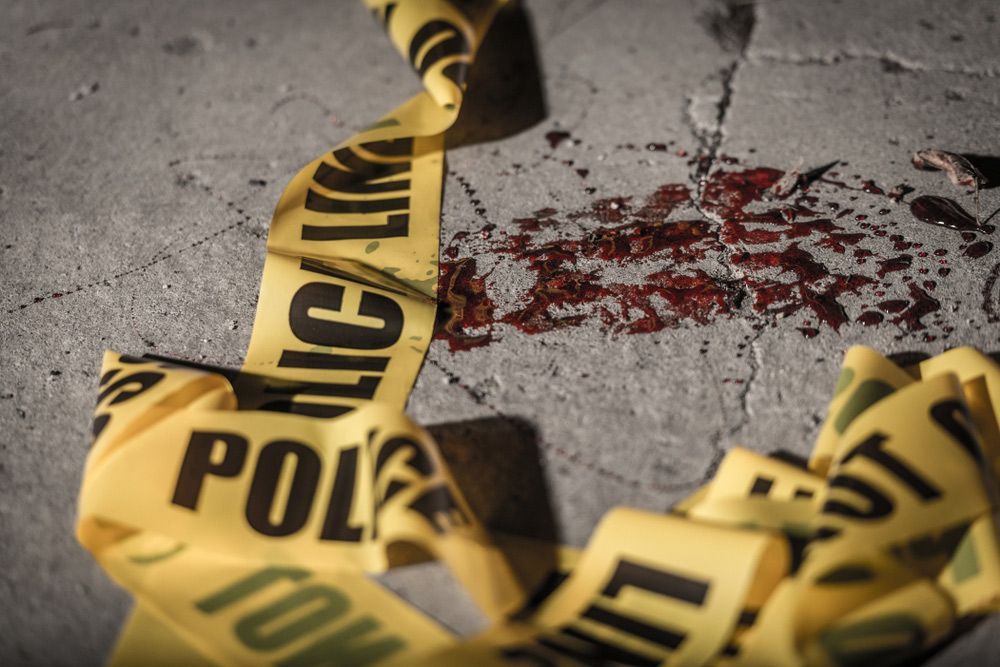 Police cordon tape lies on the ground in a small amount of blood — Criminal Law Solicitors in Muswellbrook NSW