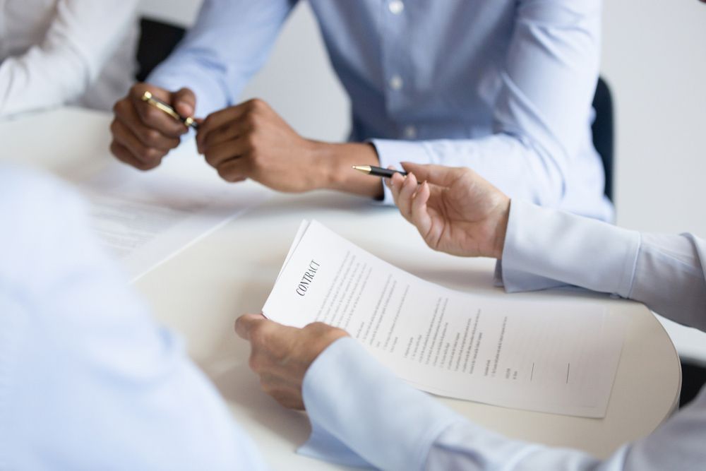 Business woman holding checking benefit reading legal paper form at group meeting — Employment Law Solicitors in Muswellbrook NSW
