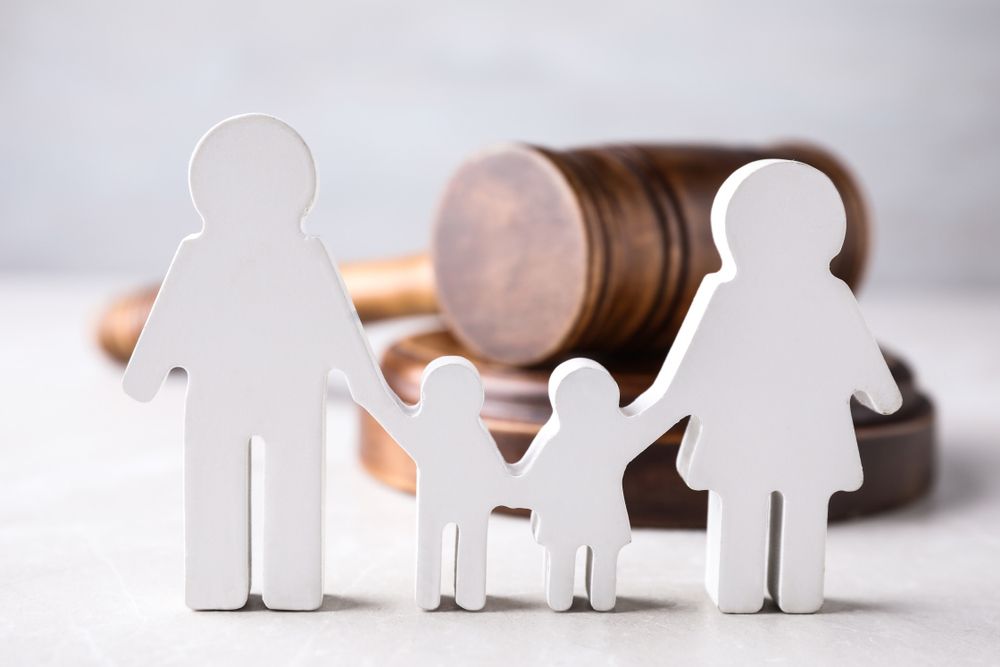Figure in shape of people and wooden gavel on light table — Solicitors in Cessnock, NSW