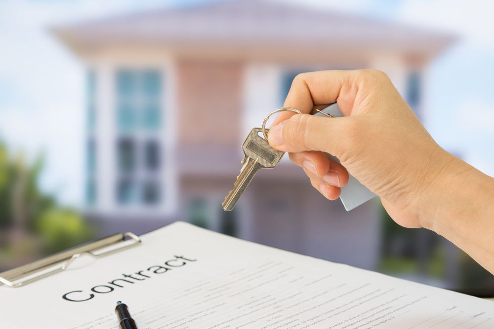 Showing house keys in front of a home with documents contract — Conveyancing in Muswellbrook NSW
