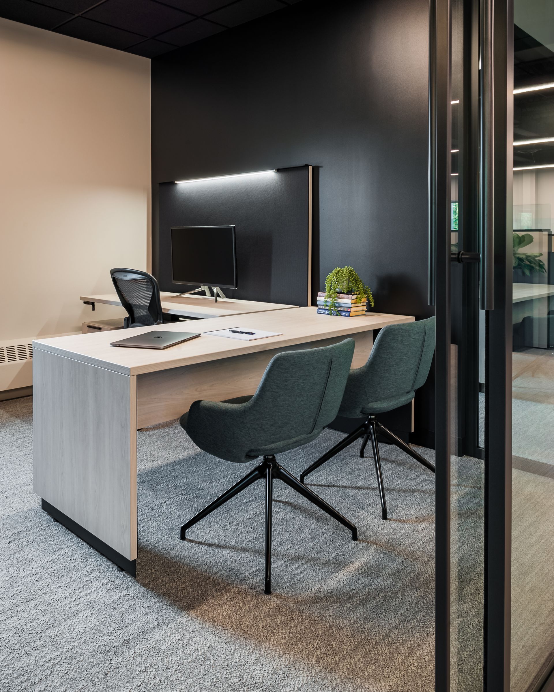 A couple of people are sitting at a table in a conference room.