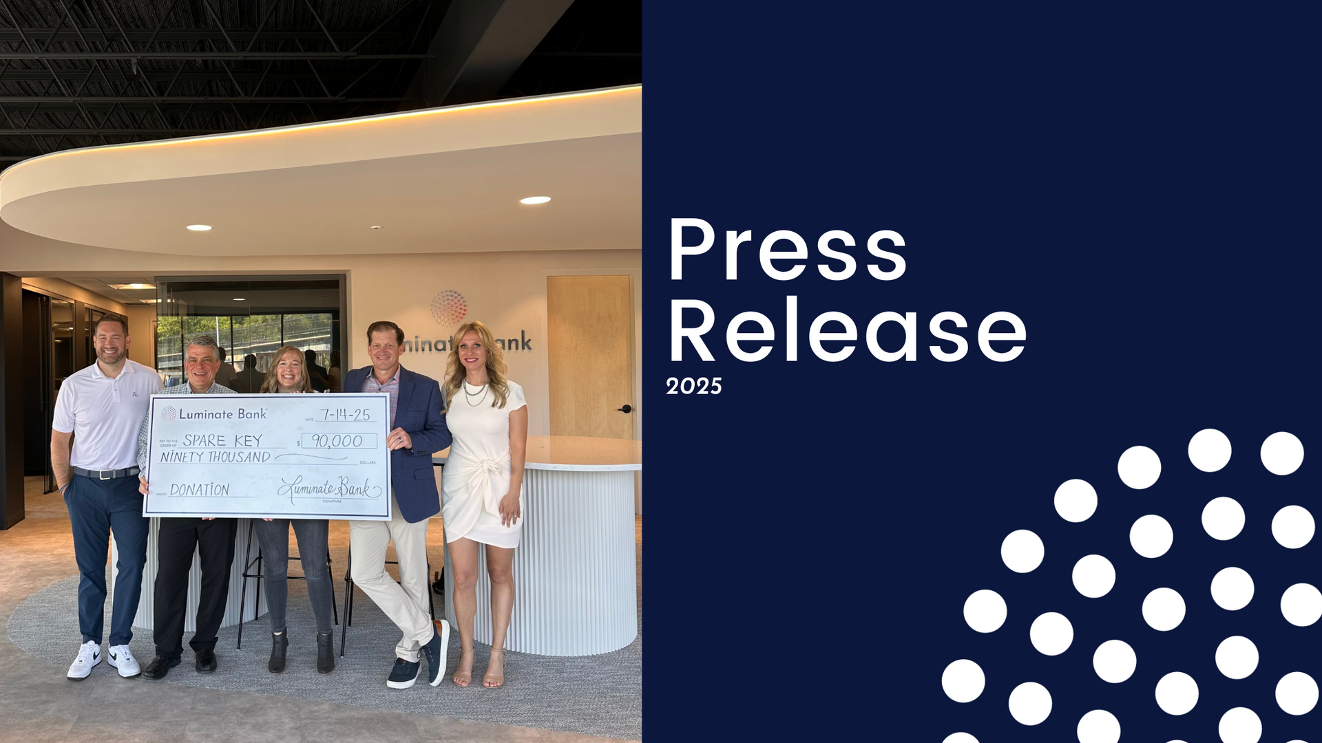 People holding a large check in front of a modern building, with 