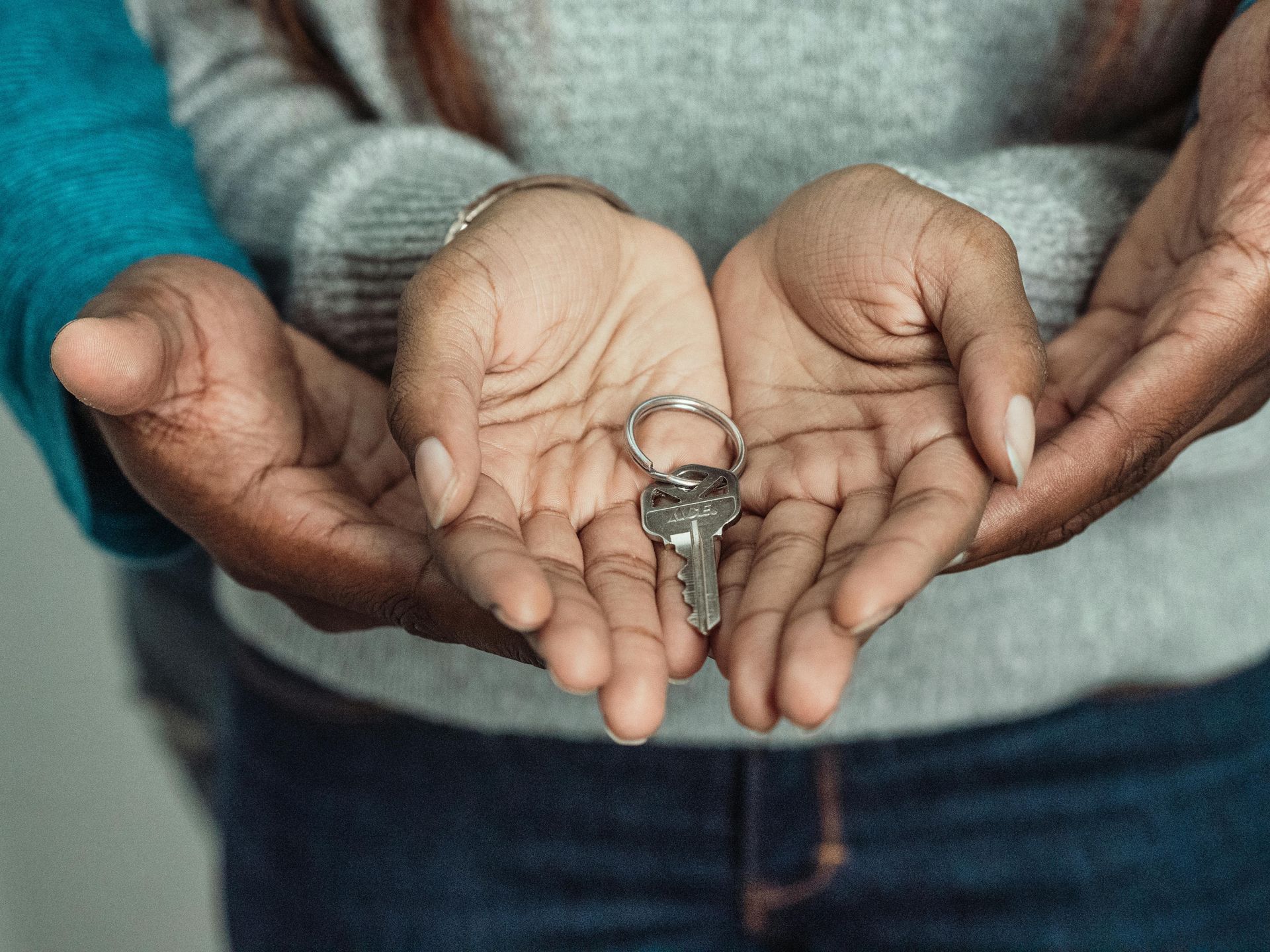 Hands holding house key.
