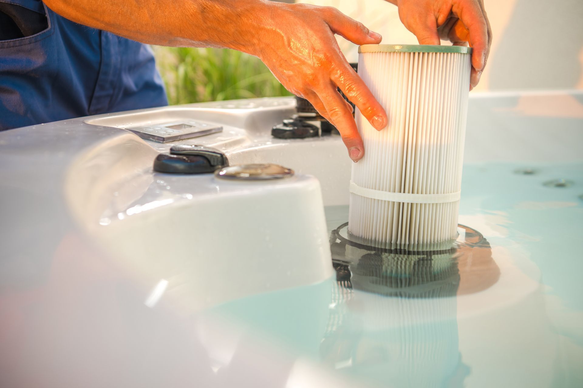 A technician is removing a water filter and performing scheduled garden spa maintenance. A technician is removing a water filter and performing scheduled garden spa maintenance.