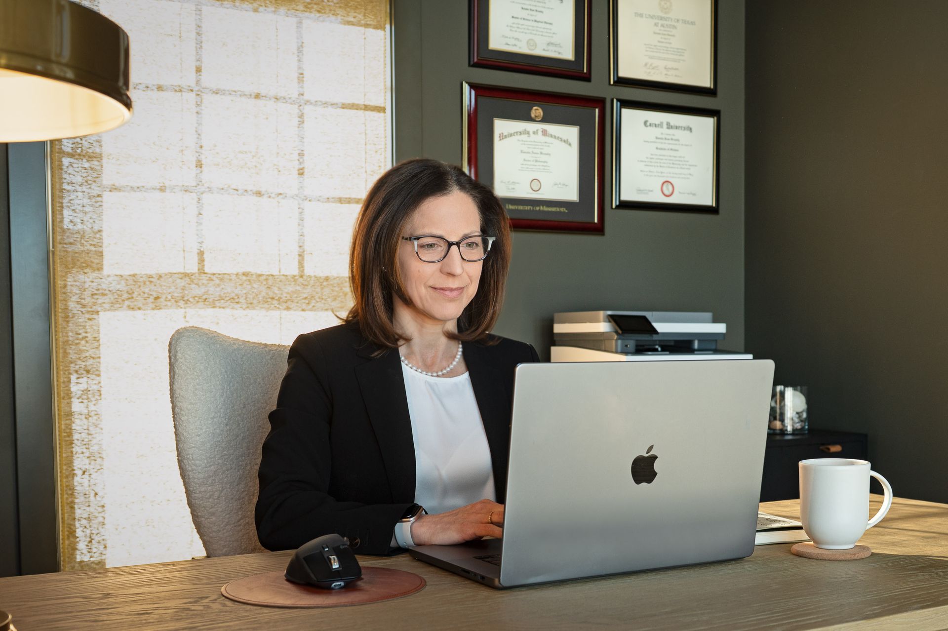 Rows of black hexagonal dumbbells on a rack in a gym.