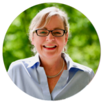 A woman wearing glasses and a blue shirt is smiling in a circle.