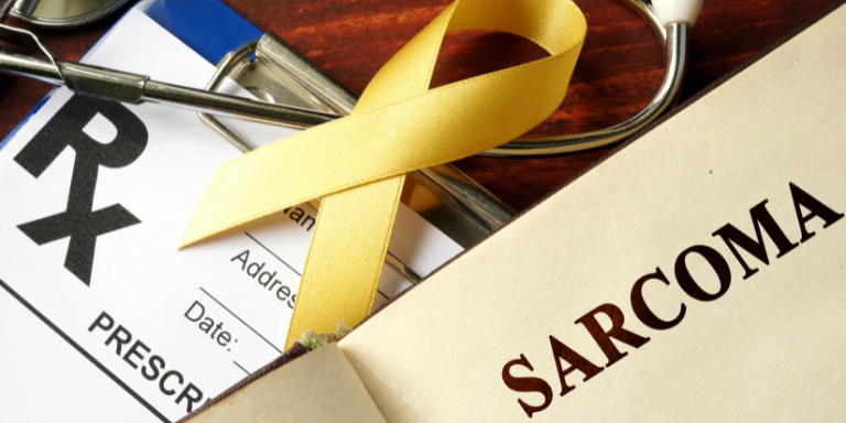 A yellow ribbon is on top of a prescription for sarcoma