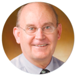 A bald man wearing glasses and a tie is smiling in a circle.