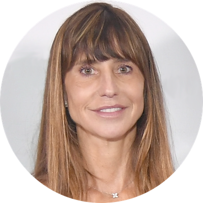 A man in a suit stands in front of two pink butterflies